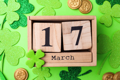Photo of Flat lay composition with wooden block calendar on light green background. St. Patrick's Day celebration