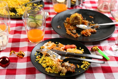 Photo of Food leftovers after party on table with checkered cloth