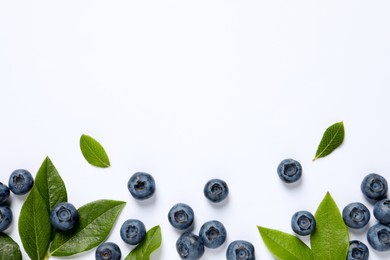 Photo of Tasty fresh blueberries with green leaves on white background, flat lay. Space for text