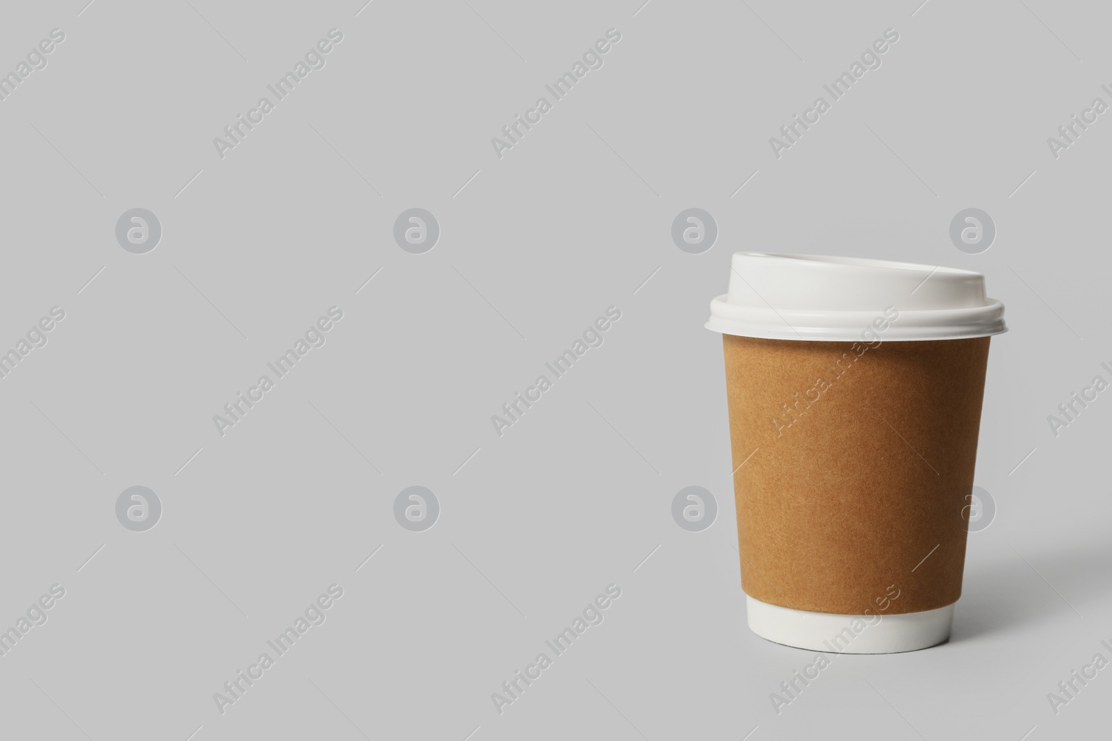 Photo of Takeaway paper coffee cup on light grey background. Space for text