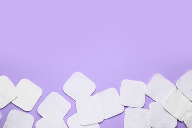 Photo of Many cotton pads on lilac background, flat lay. Space for text