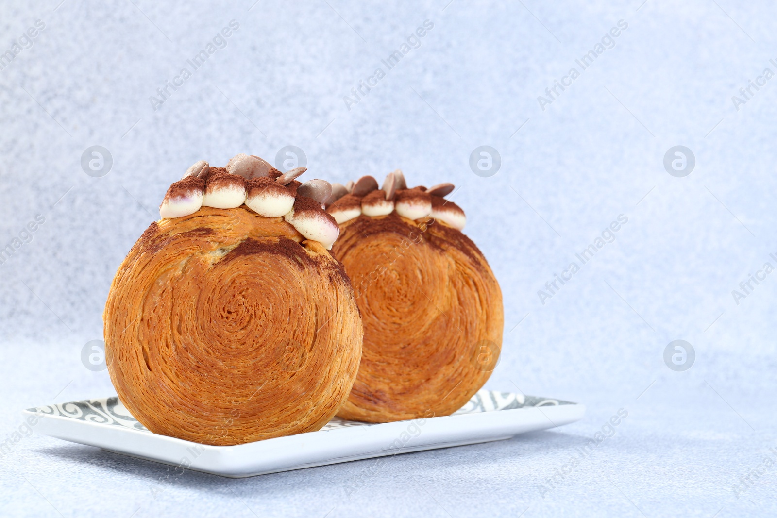 Photo of Tasty puff pastry. Supreme croissants with chocolate chips and cream on grey background, closeup. Space for text