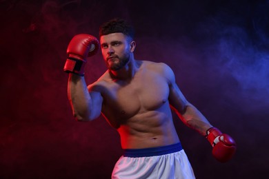 Photo of Man wearing boxing gloves fighting on dark background