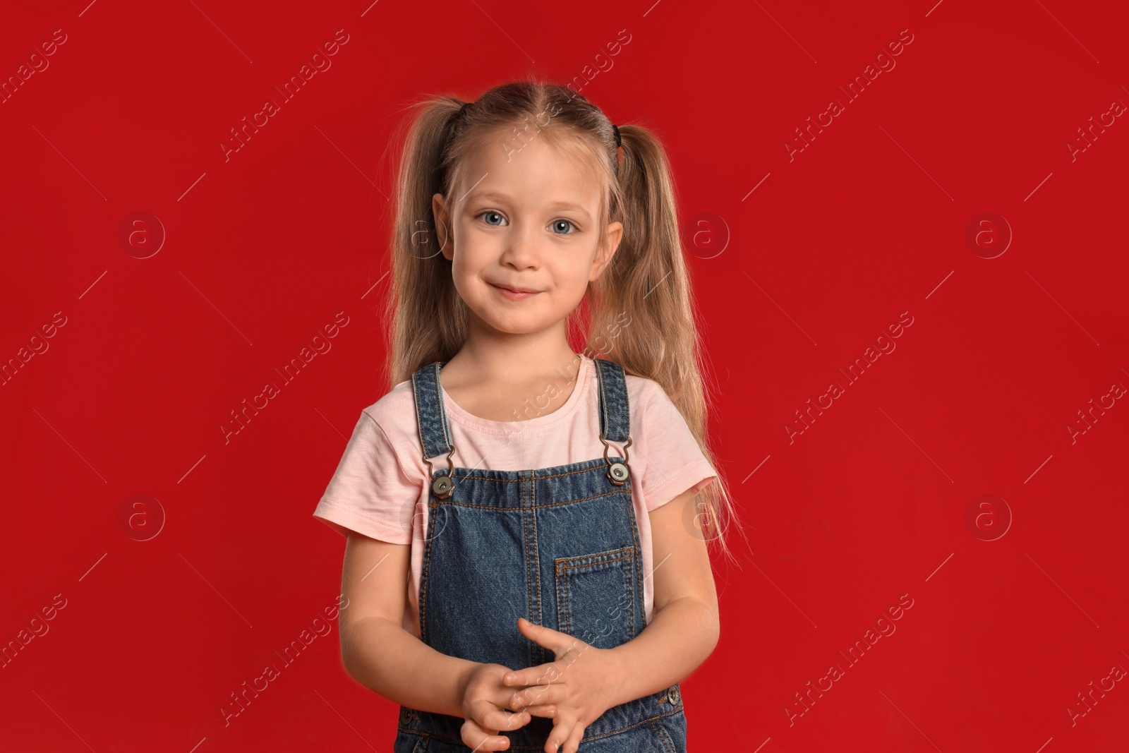 Photo of Portrait of cute little girl on red background