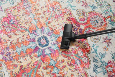 Photo of Removing dirt from carpet with modern vacuum cleaner, above view. Space for text