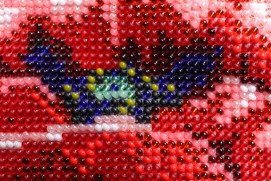 Photo of Beautiful floral bead embroidery as background, closeup