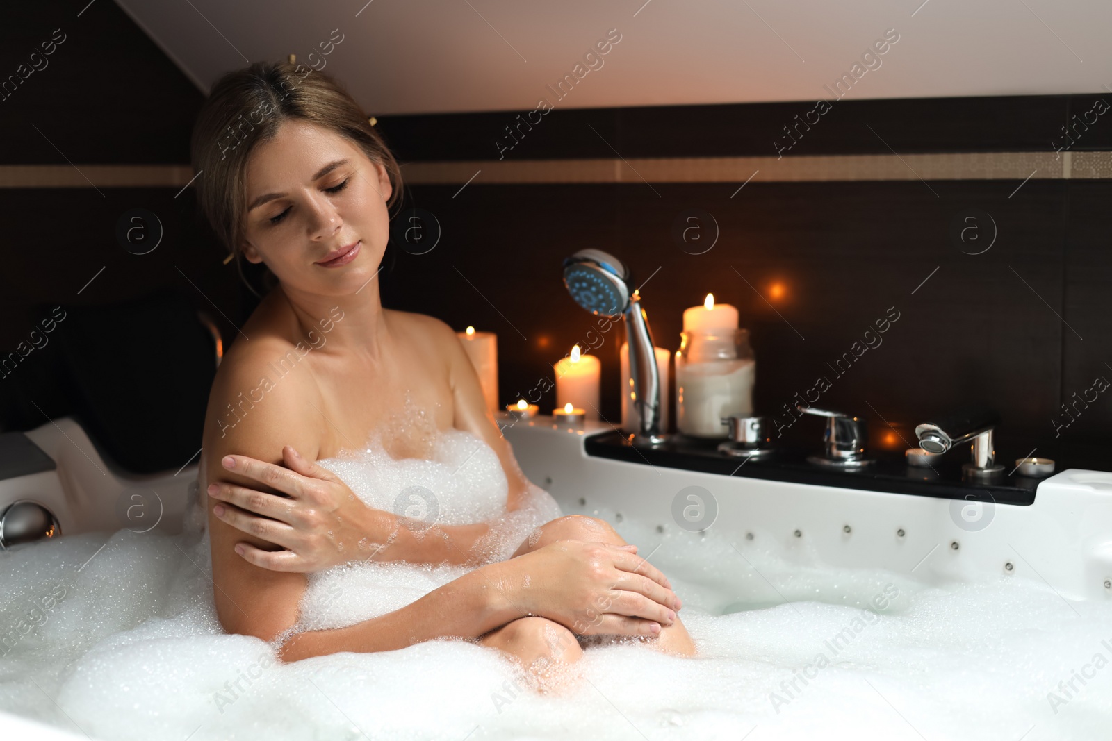 Photo of Beautiful woman taking bubble bath indoors. Romantic atmosphere