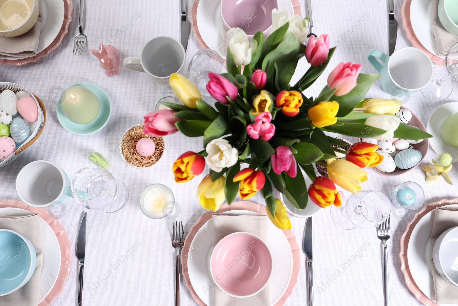 Photo of Festive table setting with beautiful flowers, flat lay. Easter celebration