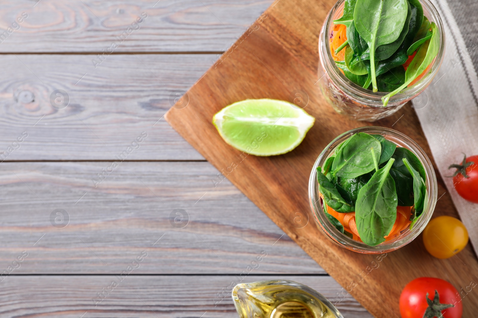 Photo of Flat lay composition with jars of healthy food on light grey wooden background, space for text