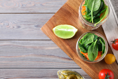 Photo of Flat lay composition with jars of healthy food on light grey wooden background, space for text