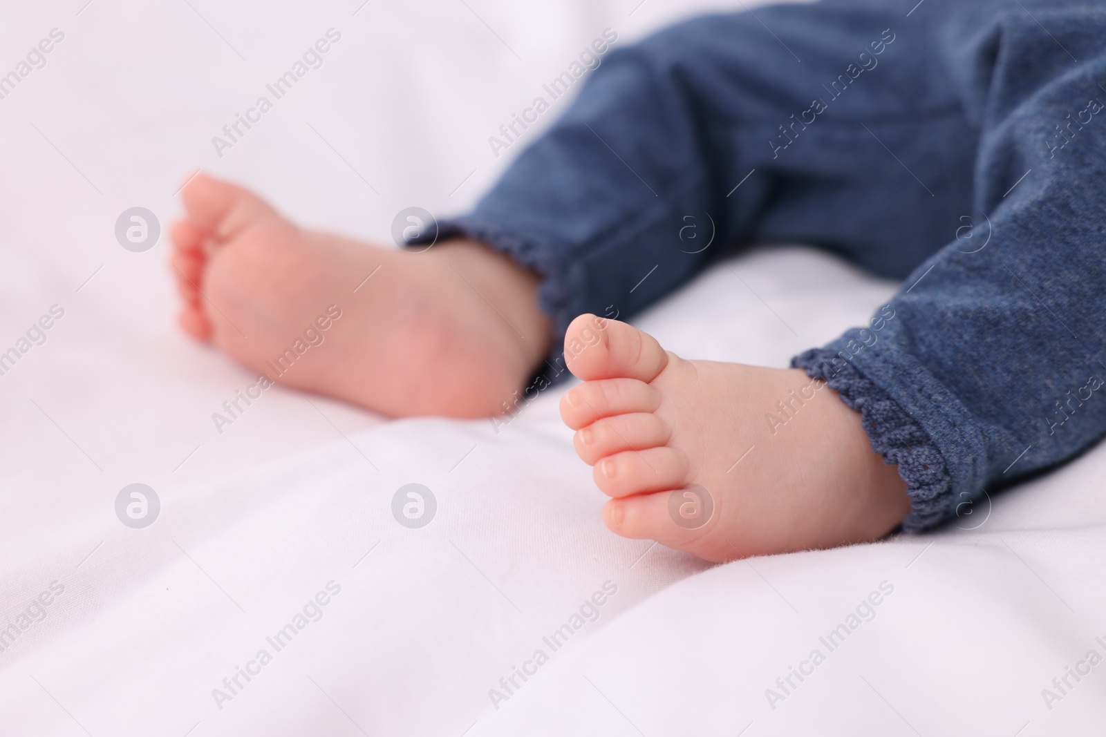 Photo of Newborn baby lying on white blanket, closeup