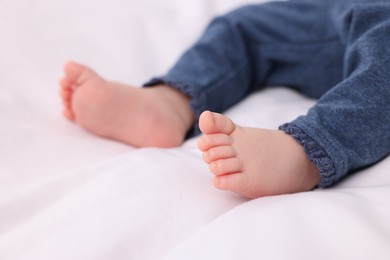 Photo of Newborn baby lying on white blanket, closeup