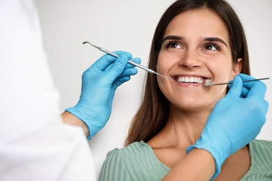 Photo of Dentist examining patient's teeth in modern clinic. Cosmetic dentistry