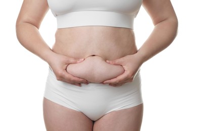 Woman touching belly fat on white background, closeup. Overweight problem