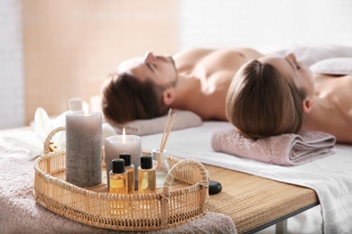 Photo of Young couple with spa essentials in wellness center