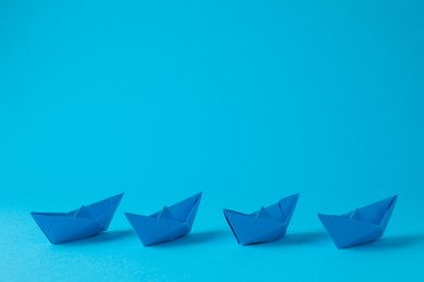 Photo of Handmade paper boats on light blue background. Space for text