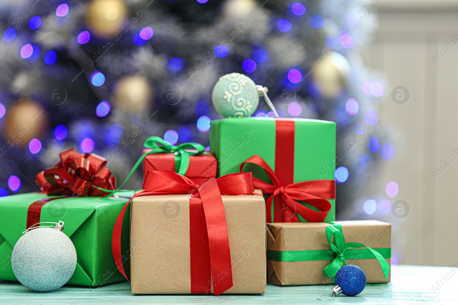 Photo of Christmas gifts on table against blurred background