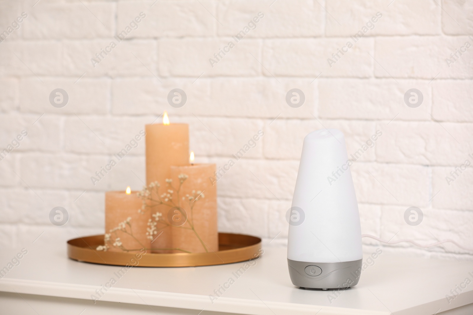 Photo of Modern essential oil diffuser on table indoors