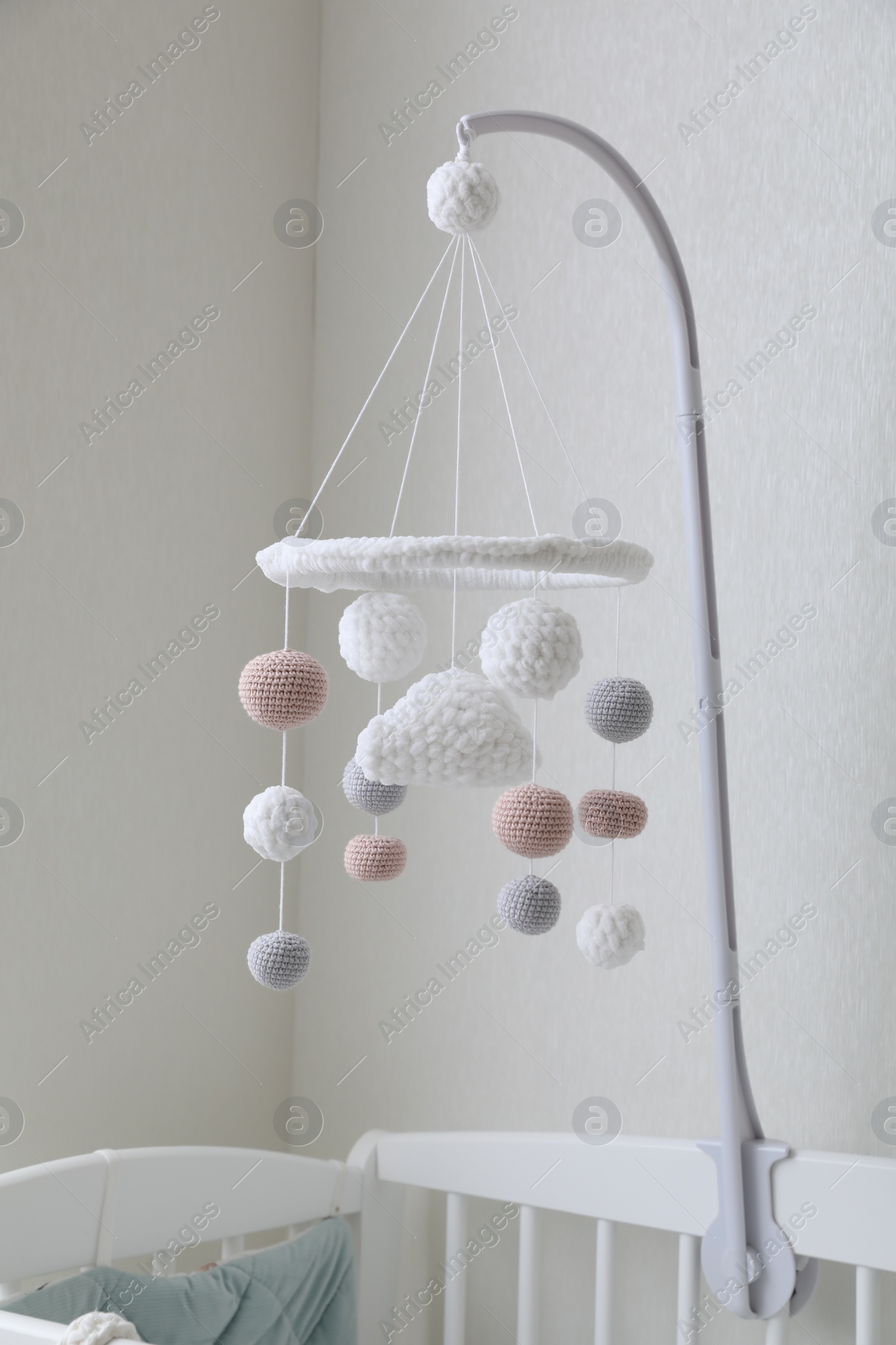 Photo of Modern baby mobile under crib in children's room