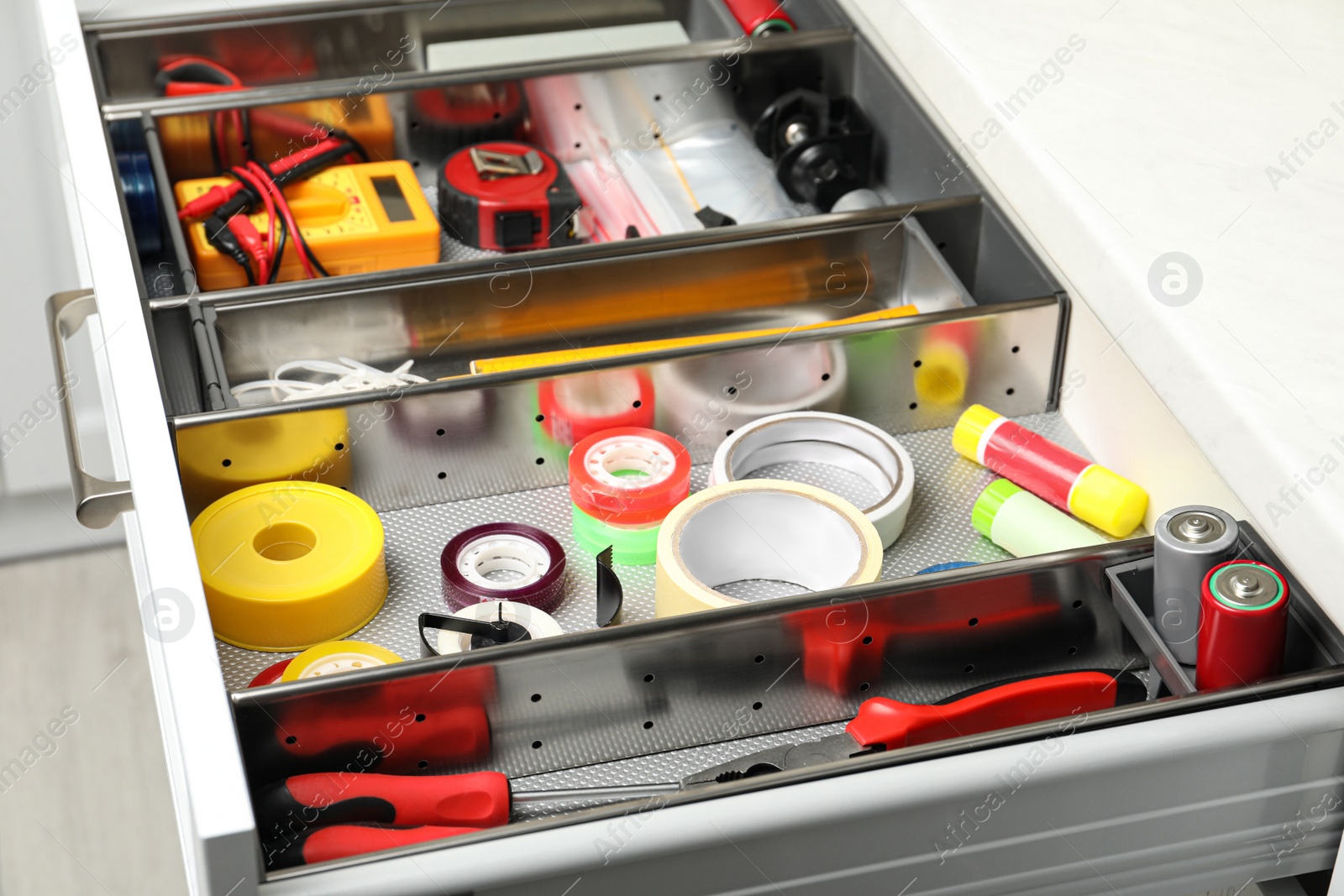 Photo of Set of instruments in open desk drawer indoors, closeup