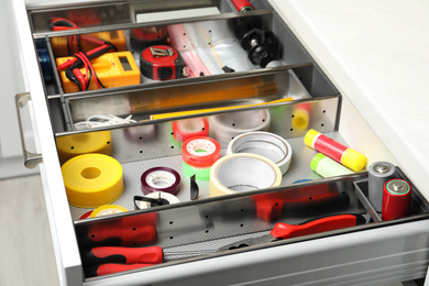 Set of instruments in open desk drawer indoors, closeup