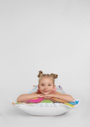 Photo of Cute little child in beachwear with bright inflatable mattress on white background
