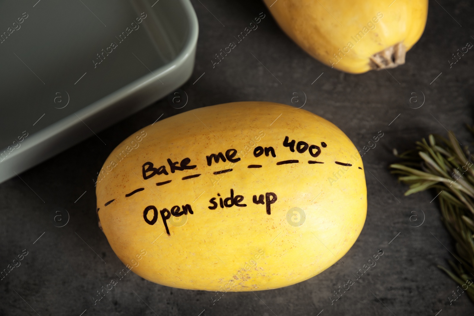 Photo of Ripe spaghetti squash with cooking instructions on gray table