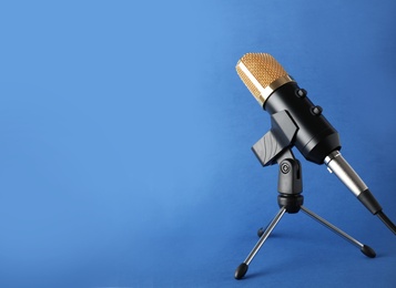 Condenser microphone on color background, space for text