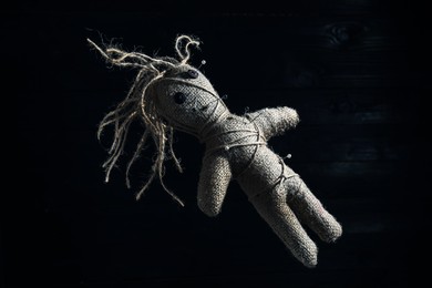 Image of Female voodoo doll with pins on dark background