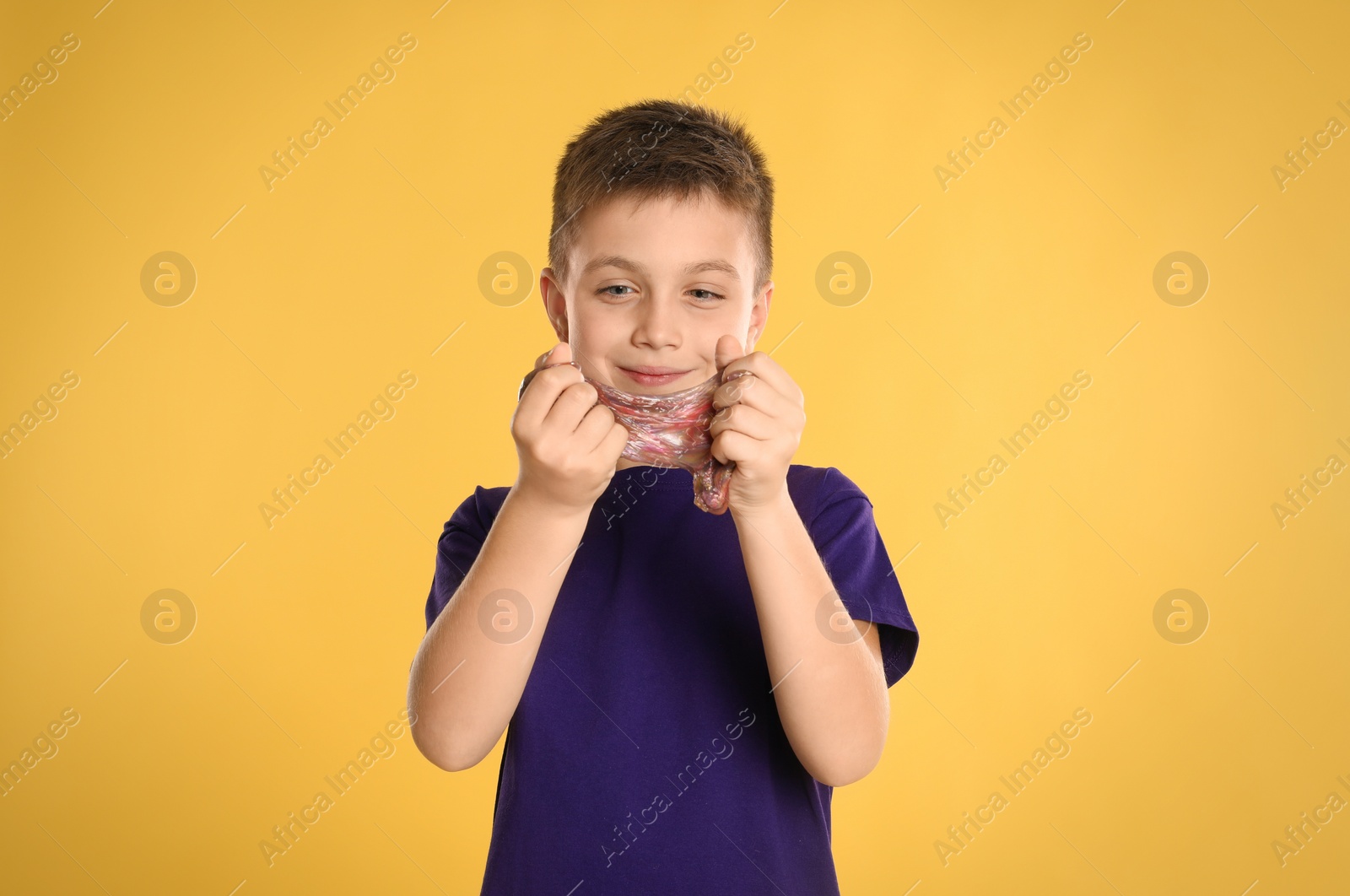 Photo of Little boy with slime on yellow background