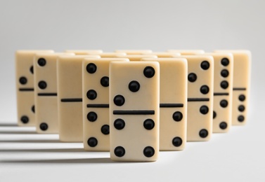 Photo of Many domino tiles on white background, closeup