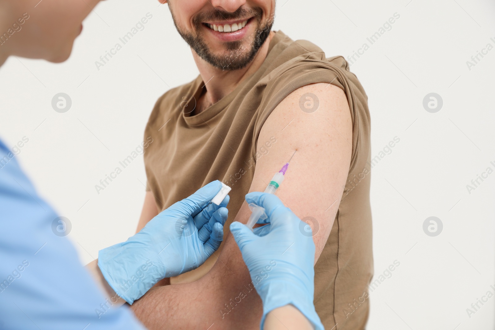 Photo of Doctor giving hepatitis vaccine to patient on white background, closeup