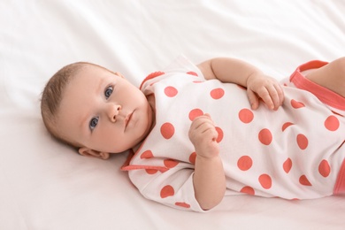 Cute little baby lying on bed at home