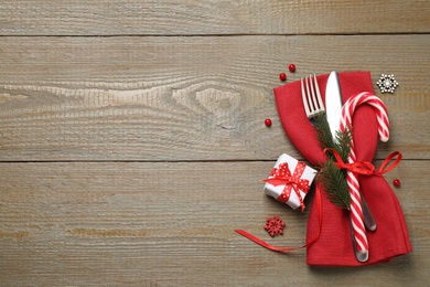 Photo of Cutlery set and festive decor on wooden table, flat lay with space for text. Christmas celebration