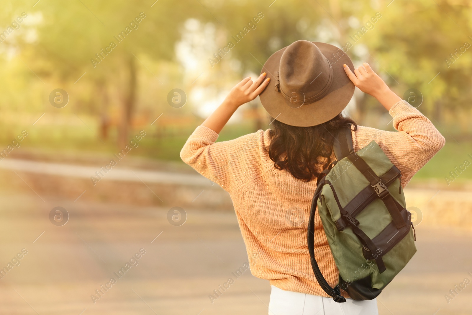 Photo of Traveler with backpack on city street, back view