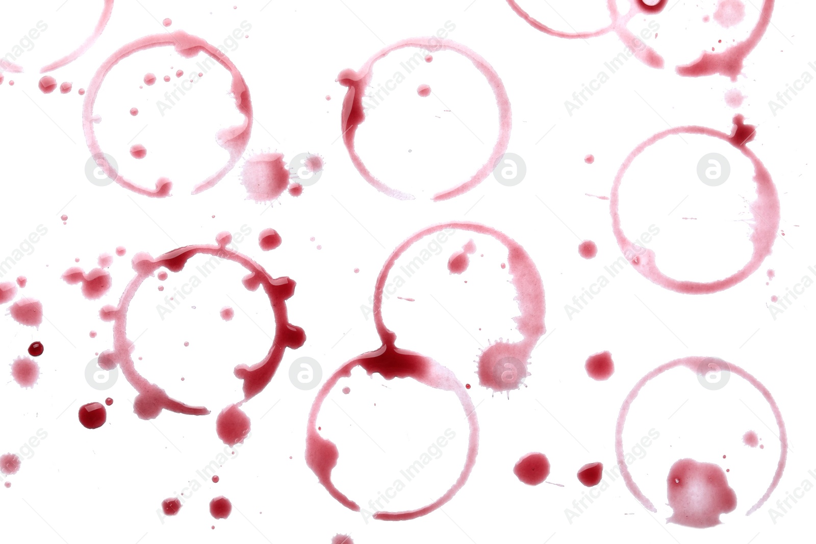 Photo of Red wine rings and drops on white background, top view