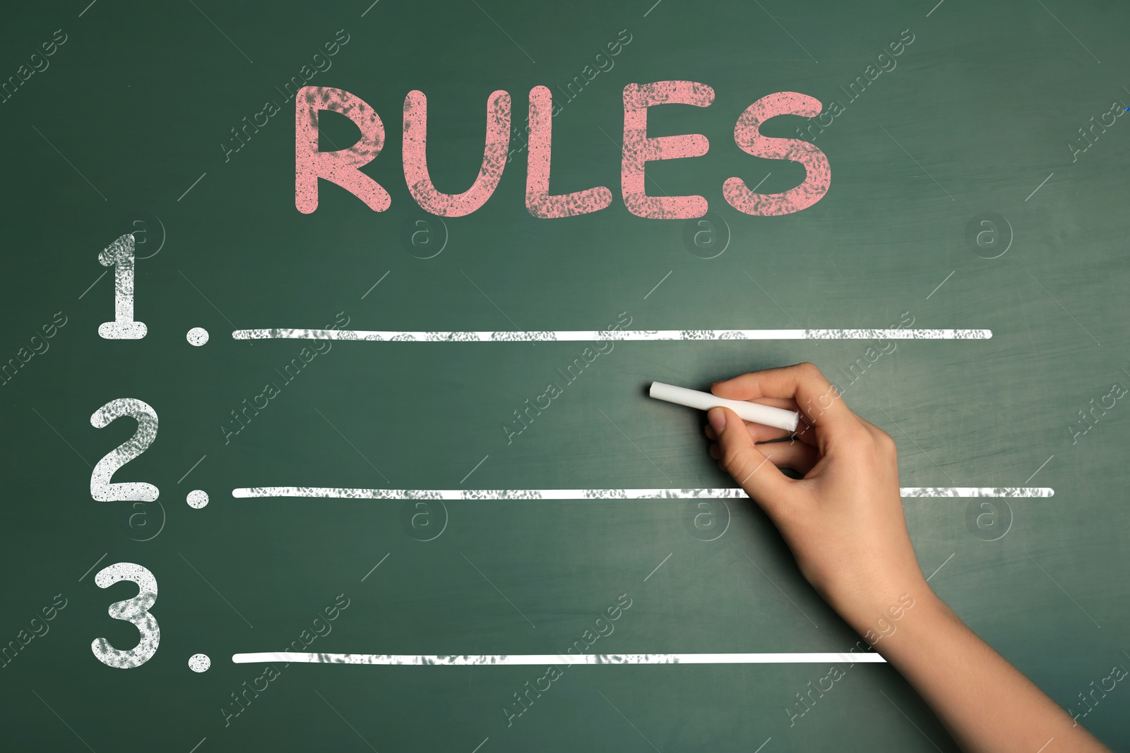 Image of Woman writing list of rules on chalkboard, closeup 