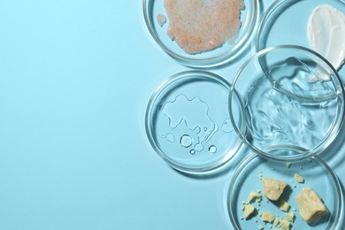 Photo of Many petri dishes with samples on light blue background, flat lay. Space for text