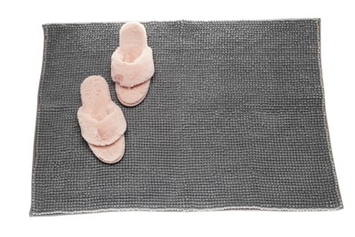 Soft grey bath mat and slippers isolated on white, top view