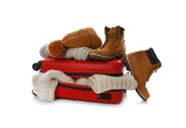 Suitcase with warm clothes isolated on white. Winter vacation