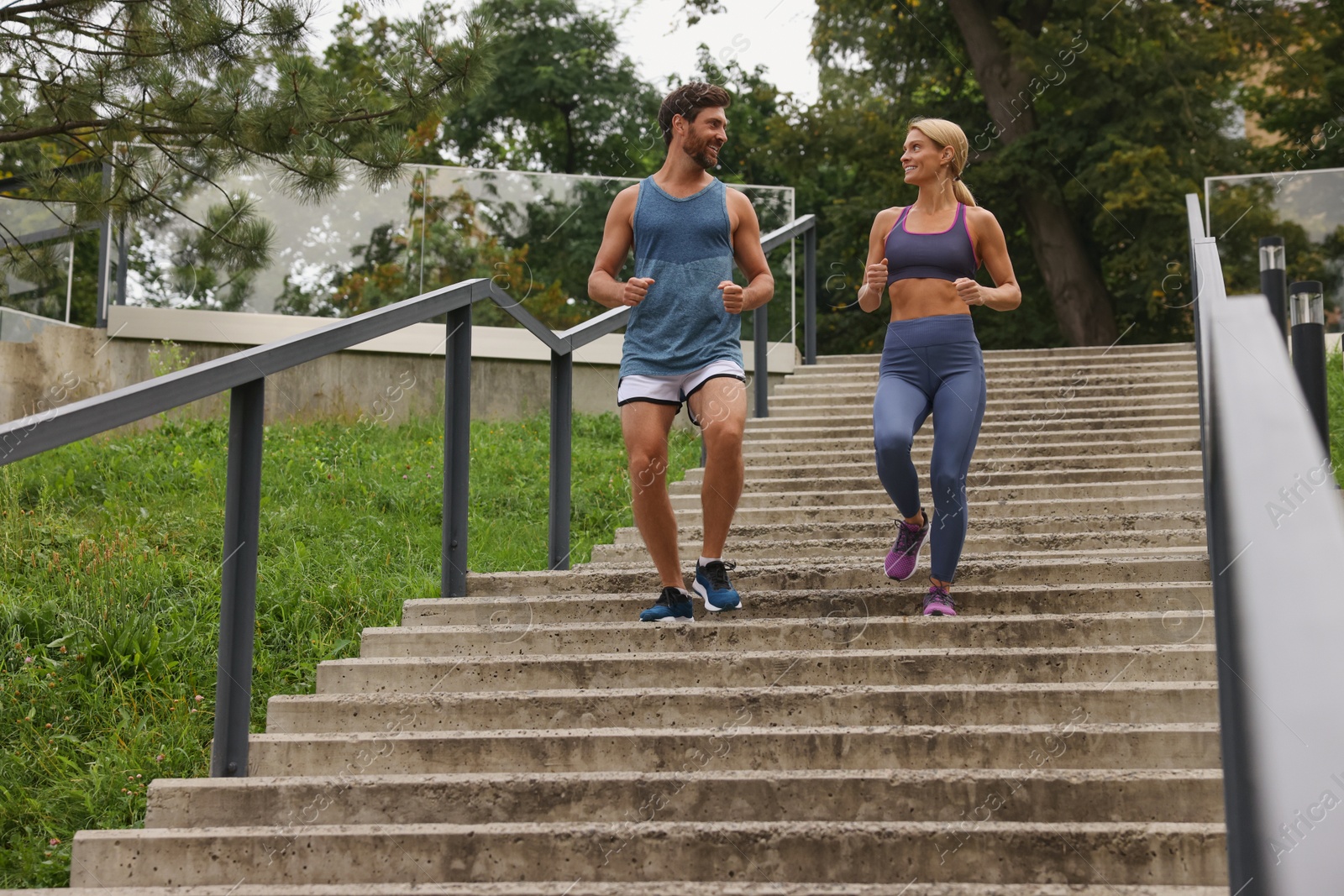 Photo of Healthy lifestyle. Happy couple running down stairs outdoors