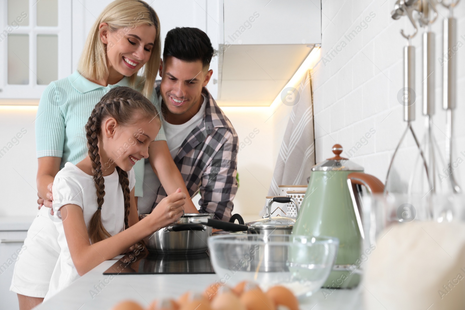 Photo of Happy family cooking together in modern kitchen