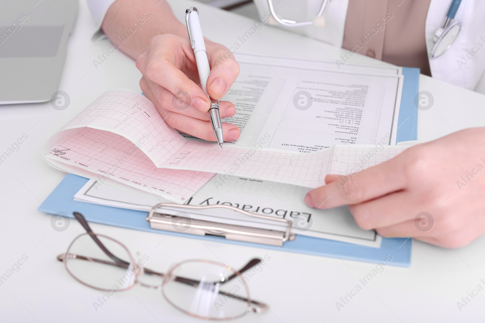 Photo of Doctor examining cardiogram at table in clinic, closeup