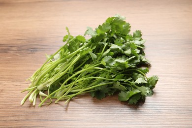 Photo of Bunch of fresh aromatic cilantro on wooden table