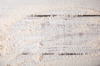 Wheat flour on white wooden table, top view