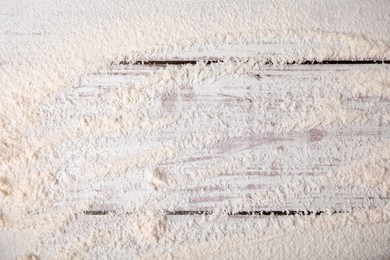 Photo of Wheat flour on white wooden table, top view