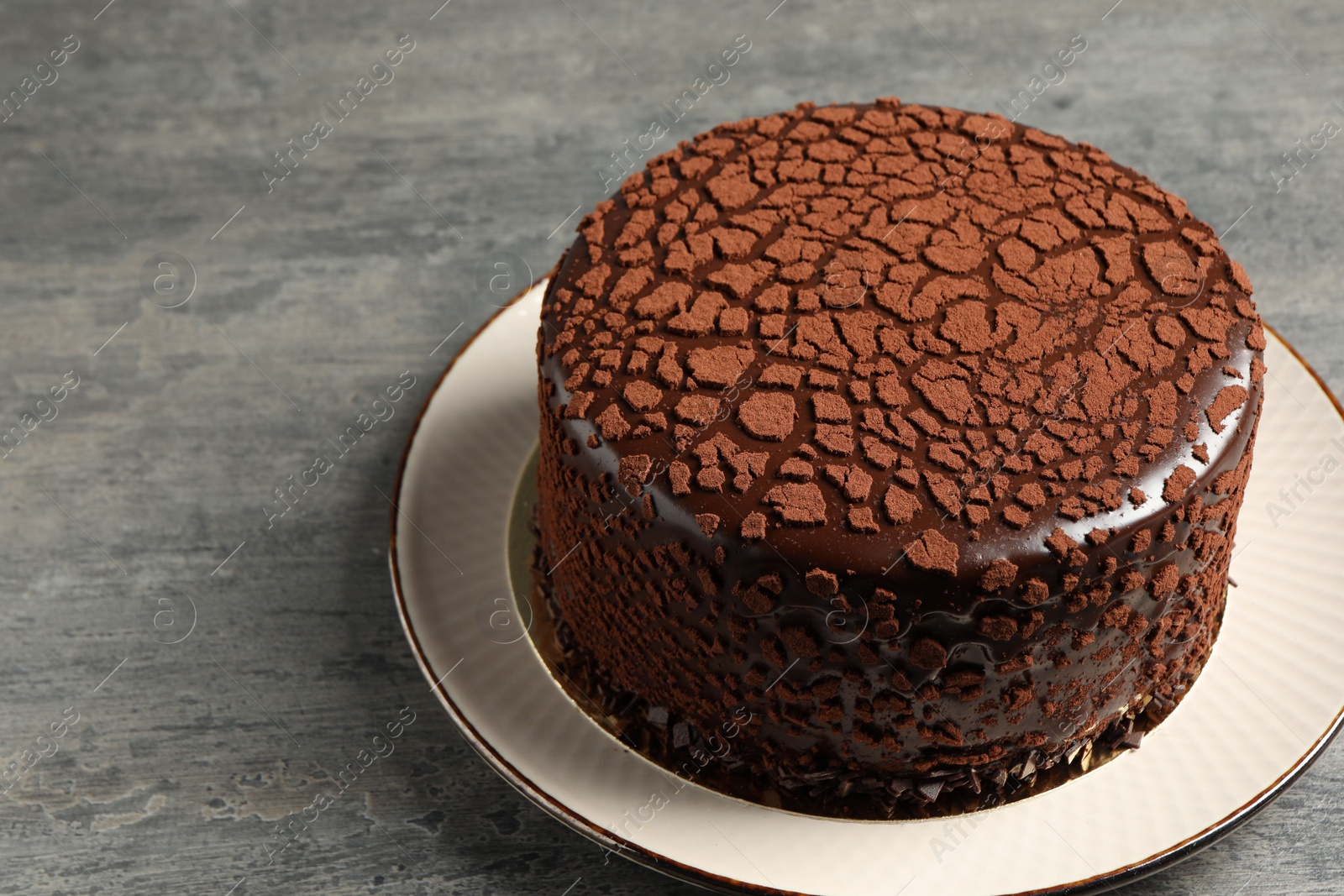 Photo of Delicious chocolate truffle cake on grey textured table, space for text