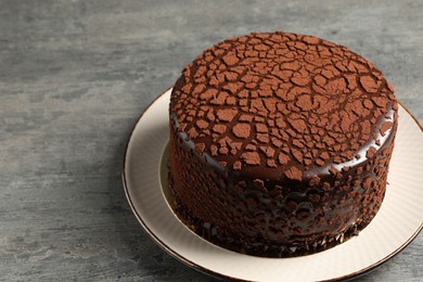 Delicious chocolate truffle cake on grey textured table, space for text