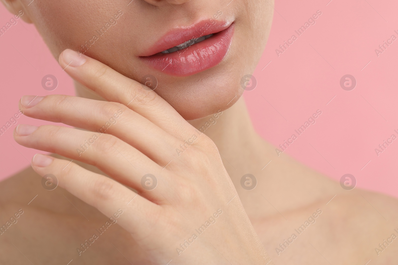 Photo of Young woman with beautiful full lips on pink background, closeup