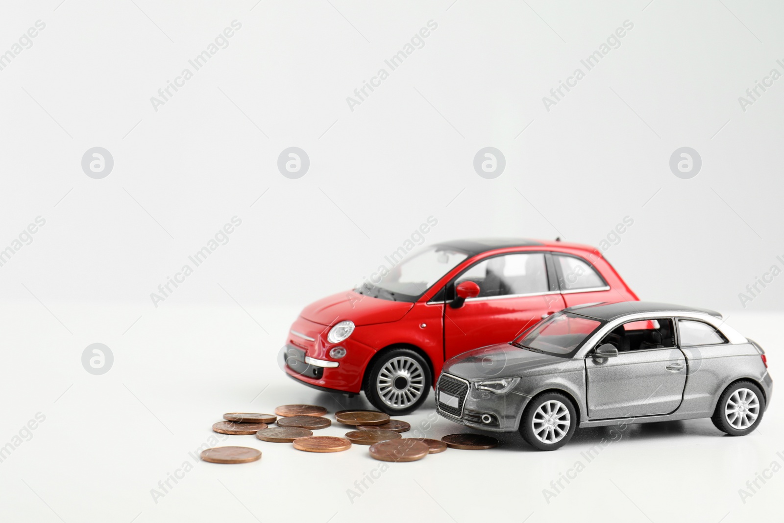 Photo of Toy cars and money on white background, space for text. Vehicle insurance